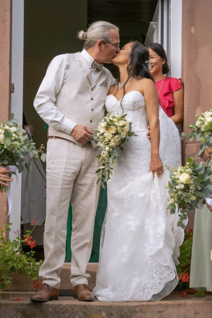 Un couple de mariés partage un baiser à la sortie de la cérémonie